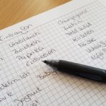 Zettel mit Kuli und Einkaufsliste