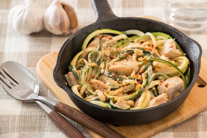 Zucchini-Nudeln mit Erdnuss-Soße in einer Pfanne