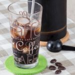 Cold Brew Coffee im Glas, Kanne im Hintergrund