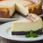 1 Stück Käsekuchen mit Mohnboden auf einem Teller